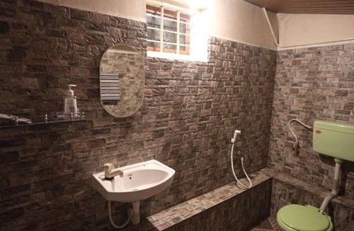 Mannarkkad Apartment | A room with a king-size bed and a view of the mountains